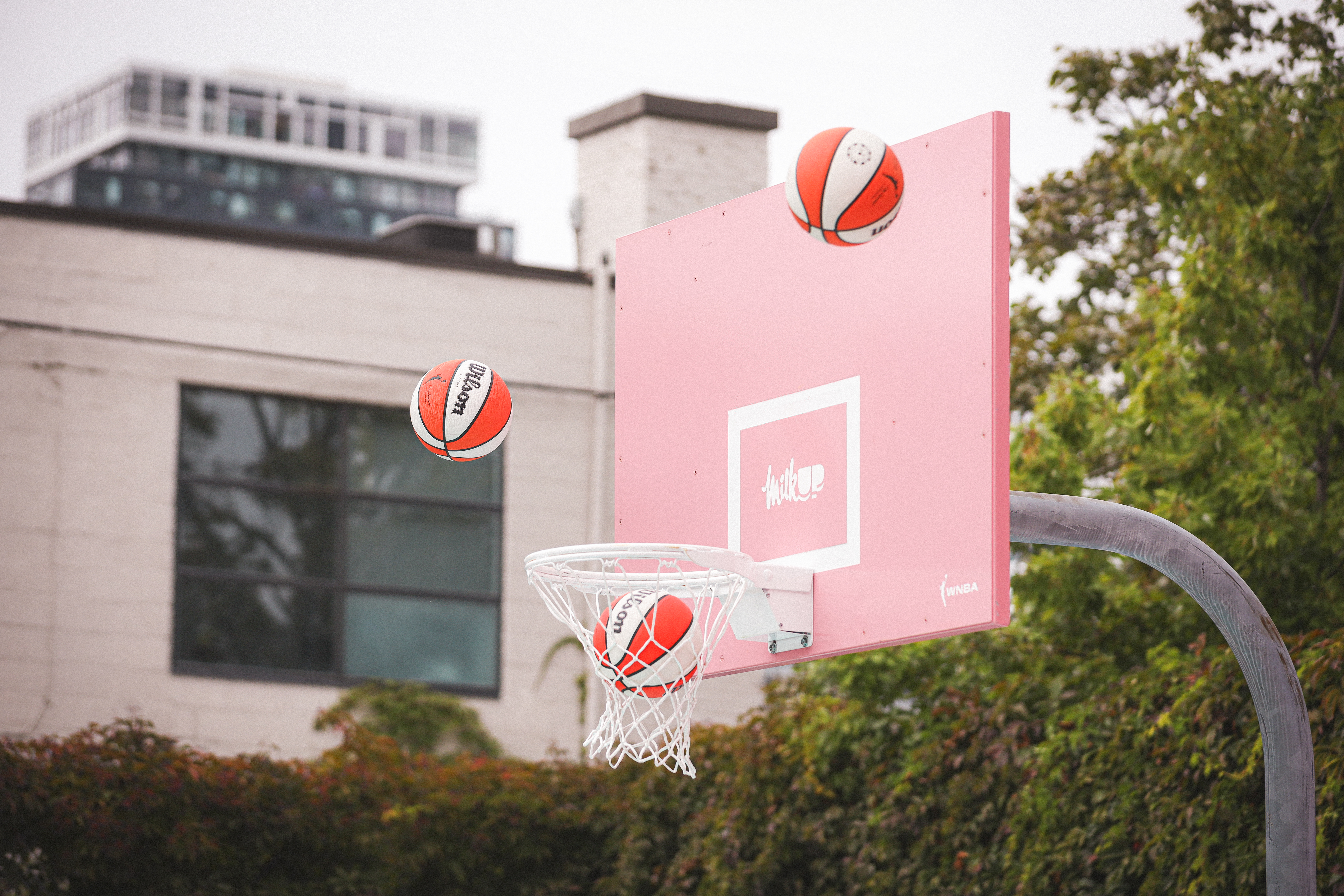 Pink backboard with balls in the air
