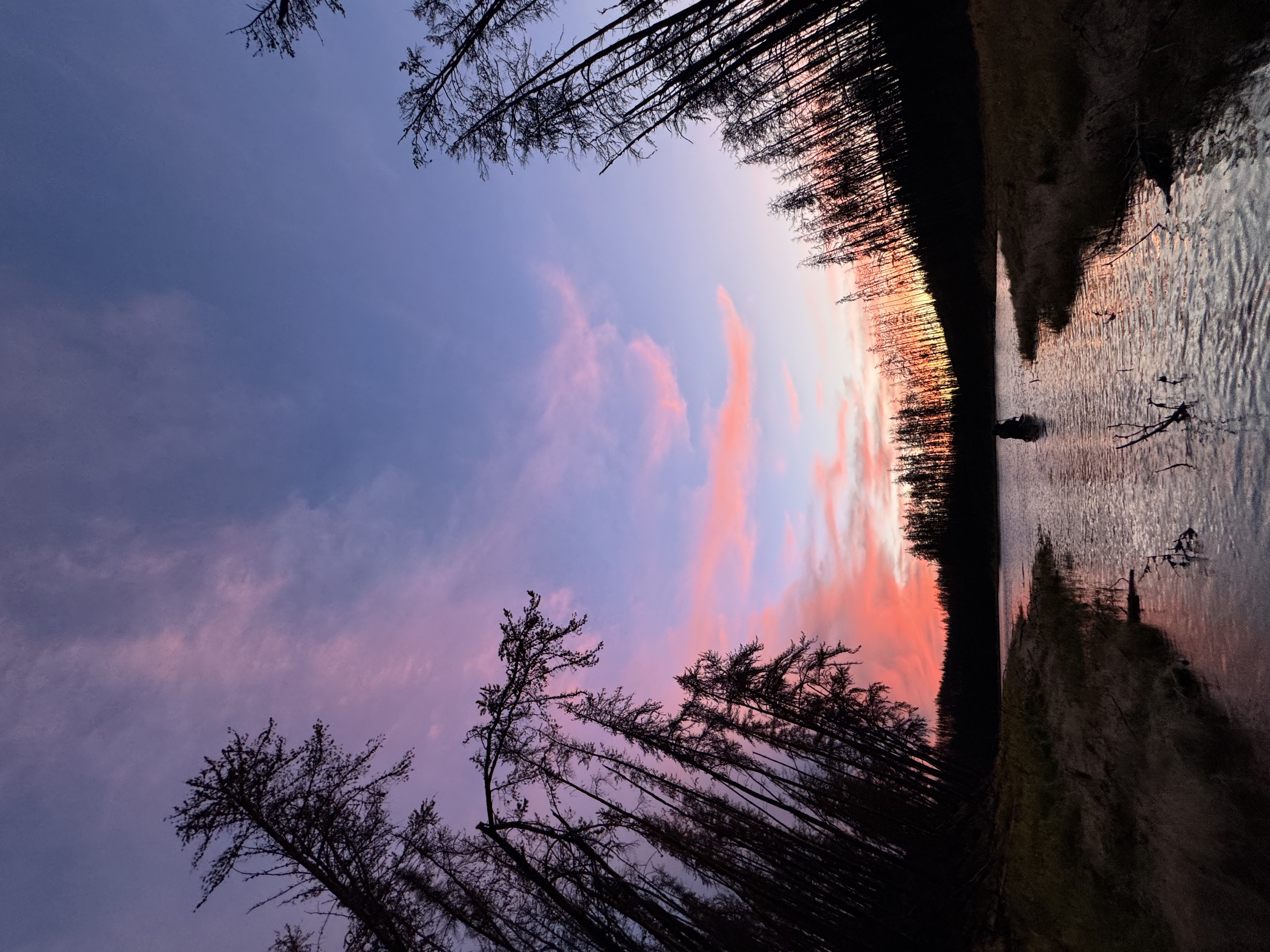 Dramatic pink and purple sunset reflected in still water