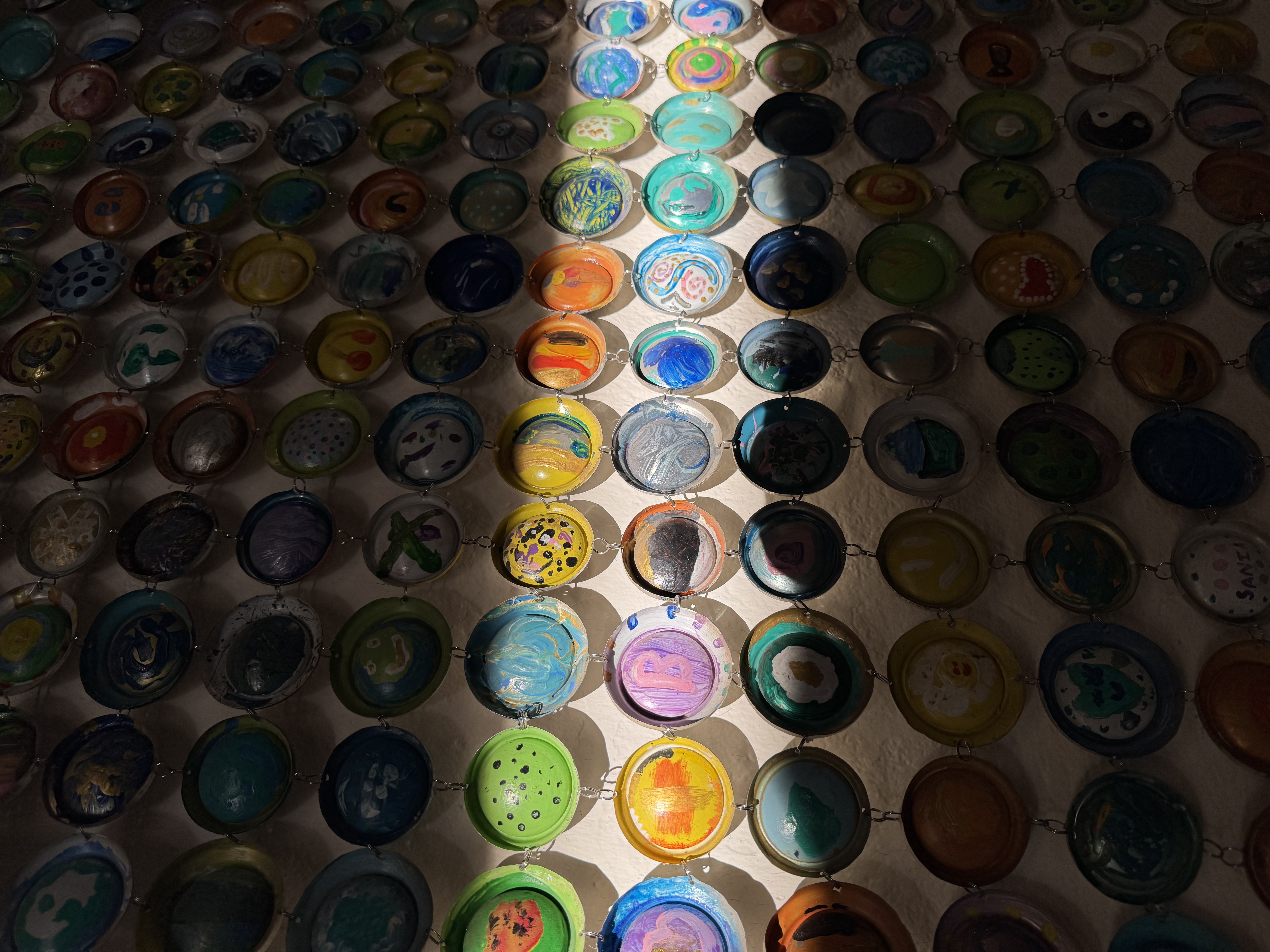 Rows of ceramic bowls lit by a beam of light